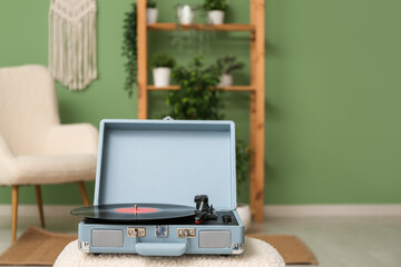 Record player with disk on coffee table in room