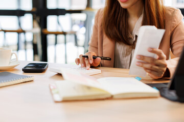 Young woman holding bills working for calculate business data, taxes, bills payment, Start up...