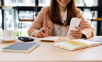 Young woman holding bills working for calculate business data, taxes, bills payment, Start up...