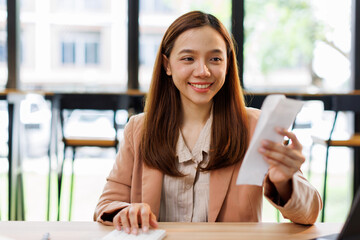 Young woman holding bills working for calculate business data, taxes, bills payment, Start up...