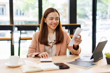 asian young woman hand checking list with bill for calculate accounting expense credit card payment...