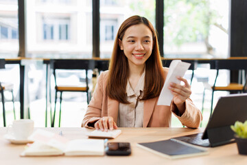asian young woman hand checking list with bill for calculate accounting expense credit card payment...
