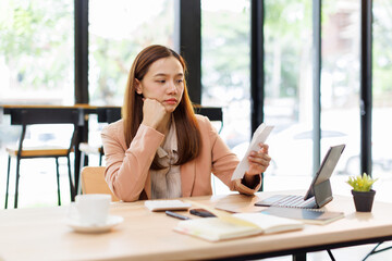 asian young woman hand checking list with bill for calculate accounting expense credit card payment...