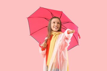 Cute teenage girl in raincoat with umbrella on pink background