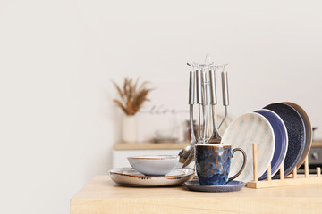 Beautiful dishes with utensils on counter in kitchen, closeup