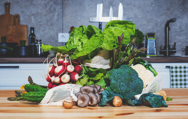 Freshly harvested vegetables and herbs arranged on a kitchen table for healthy meal preparation