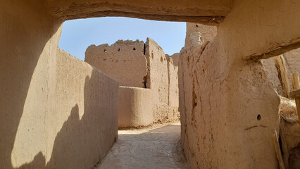 A photo of the old mud houses in Najd, Saudi Arabia, featuring wooden doors, earthen walls, narrow alleys, and handcrafted details that preserve the heritage of our ancestors.
