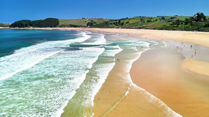 A stunning and beautiful beach scene showcasing vibrant turquoise waves alongside sunkissed sandy...