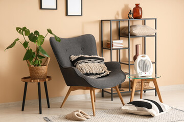 Interior of stylish living room with modern electric fan heater and grey armchair
