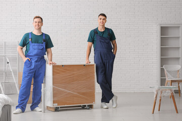 Male loaders wrapping commode with stretch film in room