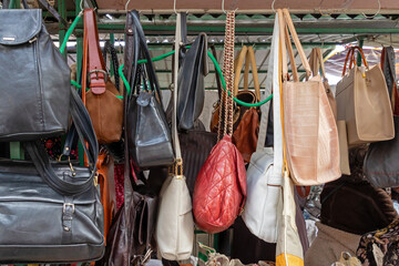 Female colorful fashion bags hanging on market stall 