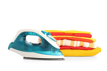 Modern iron with stack of clean clothes isolated on white background