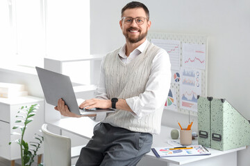 Obraz na płótnie Canvas Young man working with laptop in office