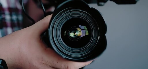 Analyzing modern camera lens reflection with expert hands for photography project