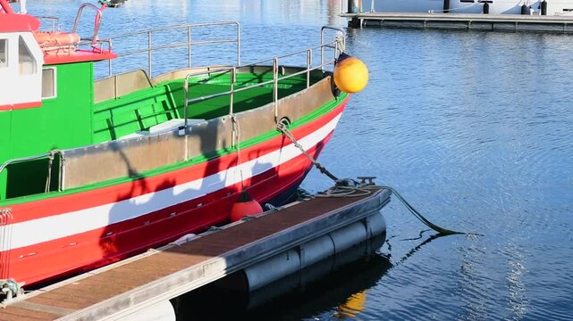 barco peque&ntilde;o de color rojo y verde aparcado en un puerto