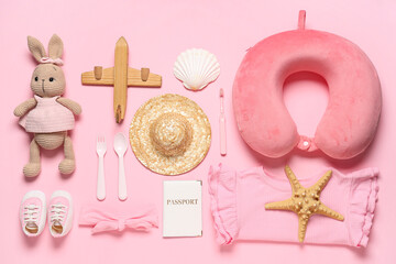 Composition with children's clothes, passport and toys on pink background