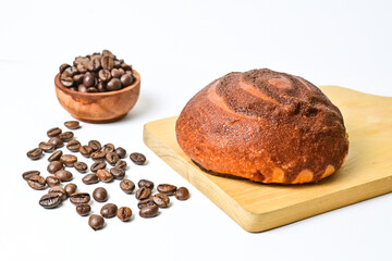 Close up view of coffee bun on wooden cutting board with roasted coffee beans in the little wooden bowl isolated on white background. Coffee bun bread home made. Mexican Coffee Bun. clipping path.