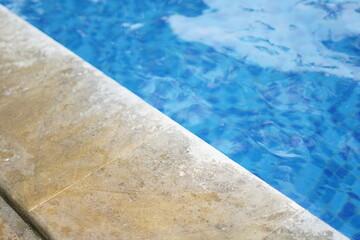 Background of the edge of the swimming pool with blue water