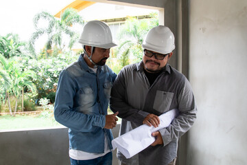Hispanic engineer man with mustache wearing safety white helmet consult team project manager...