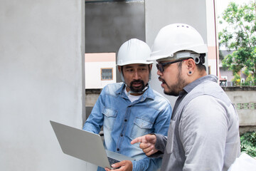 Hispanic engineer man with mustache wearing safety white helmet consult team project manager...