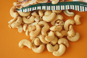 Cashew nuts scattered on an orange surface