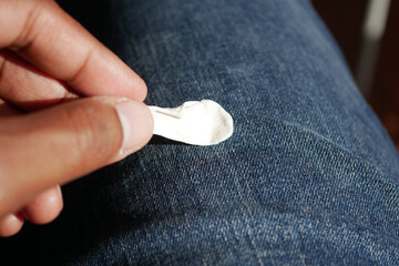 A hand removing gum from fabric under sunlight