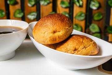 horizontal photo of traditional handmade whole wheat mogolla bread next to a cup of coffee in a healthy vegetarian restaurant in Colombia