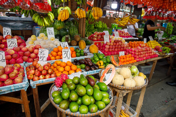 Colorful tropical fruits at public market stall in Philippines with price tags and fresh produce on display