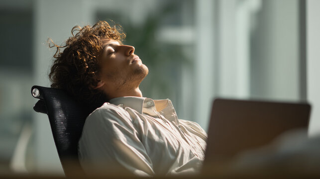 An office worker in a shirt sleeping at the office desk, exhausted from work, showing tiredness, stress, and fatigue in a corporate workplace environment.