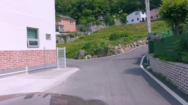 A drive up a slightly steep hill in a quaint rural village, South Korea. Captures the charming countryside and a gentle uphill journey. Ideal for peaceful village scenes or scenic travel.