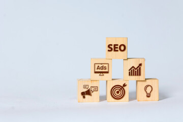 Wooden blocks arranged in a pyramid with the word SEO on top, showing various digital marketing...