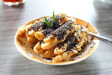 Pisang goreng or fried banana on a plate. with chocolate topping.