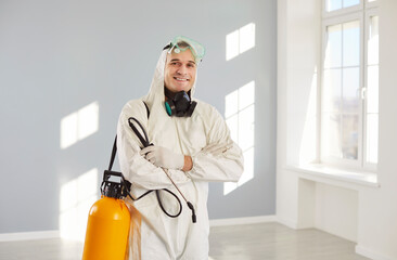 Portrait of a man from pest control standing at home with spraying equipment. professional insect...