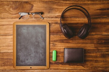 Small chalkboard is sitting on wood desk in flat design, showing glasses, headphones, wallet, USB