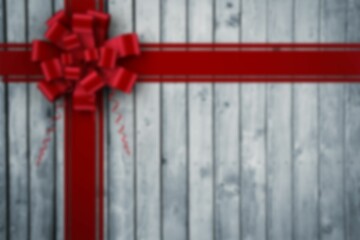 Flat design is featuring bright red satin ribbons forming cross with bow on grey plank background