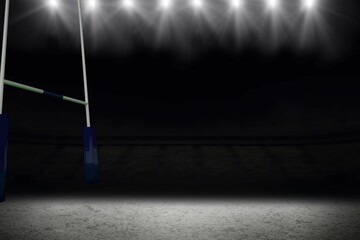 Tall goal post is standing on empty stadium field at night, floodlights are shining brightly