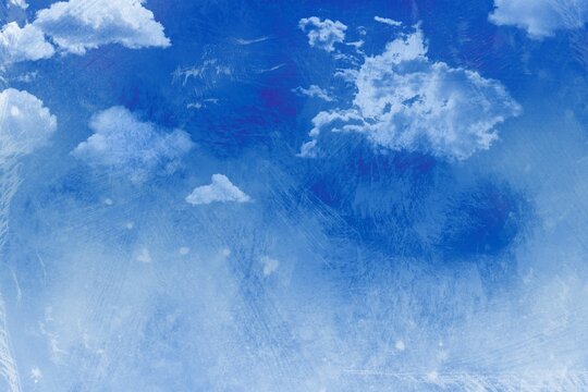 Fototapeta Deep blue sky is spreading across canvas, showing fluffy clouds and distressed painterly texture
