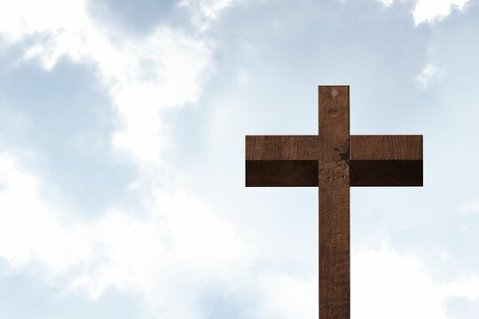 Fototapeta Wooden cross is standing against bright cloudy sky in flat design with natural texture