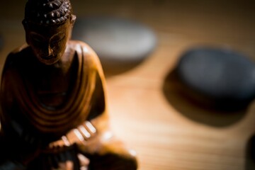 Wooden Buddha figurine and pebbles