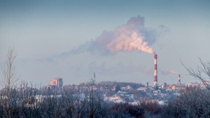 Industrial chimney smokes over the city. Environmental and air pollution. Ecology.