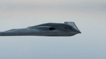 The B-2 Spirit stealth bomber is flying in the sky on a secret mission. - Powered by Adobe