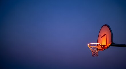 Illuminated Basketball Hoop at Dusk Against a Deep Blue Sky