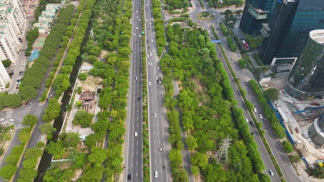 Aerial drone shot showing smooth vehicle movement on a Noida road during peak hours.