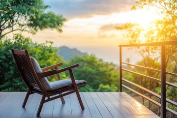 Fototapeta premium Relaxing wooden chair on a resort vacation home terrace overlooking a lush landscape at sunset