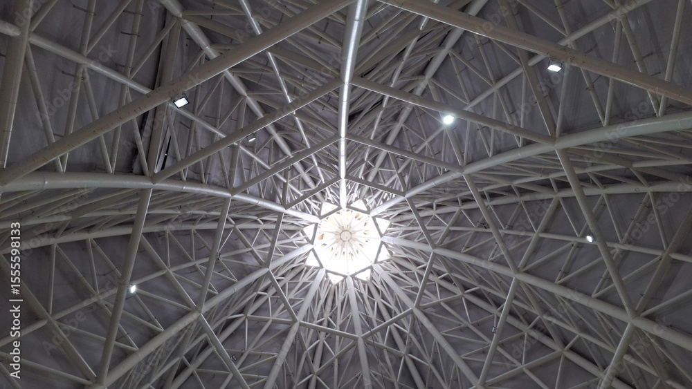 Wall mural symmetrical view of a modern architectural ceiling featuring a geometric steel framework and a centr