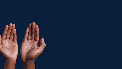 Two open hands raised, dark backdrop