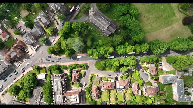 Vehicles passing through crossroads in urban neighbourhood. High angle view of traffic in city outskirt