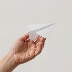 A hand holding a paper airplane, a symbol of dreams and travel
