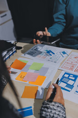 Group of young application developers analyzing uxui mobile app templates during a working meeting