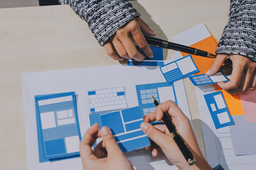 Group of young application developers analyzing uxui mobile app templates during a working meeting